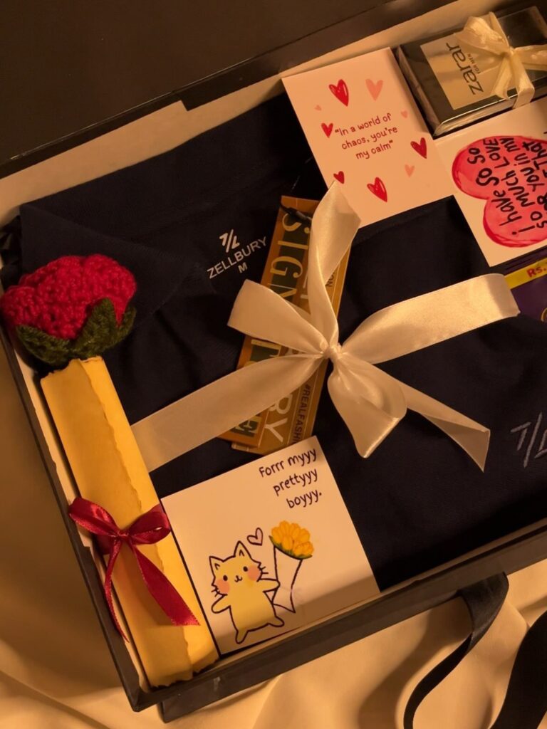 Gift box with navy t-shirt, crochet flower, chocolate, and romantic handwritten notes.