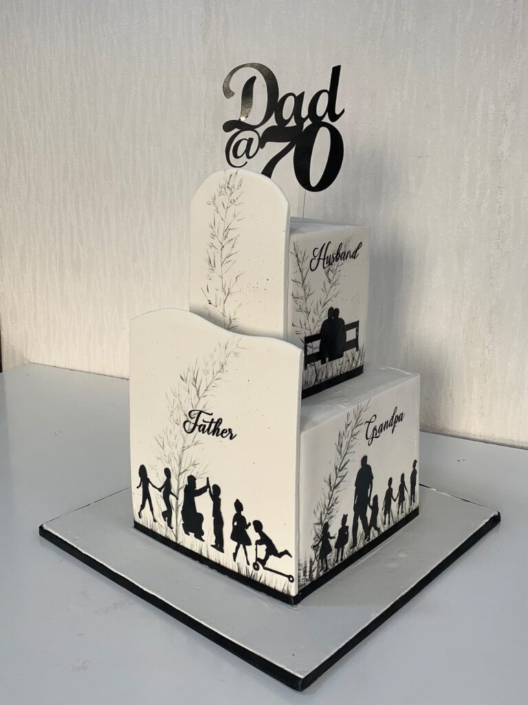 White tiered birthday cake with black family silhouettes and Dad @ 70 topper