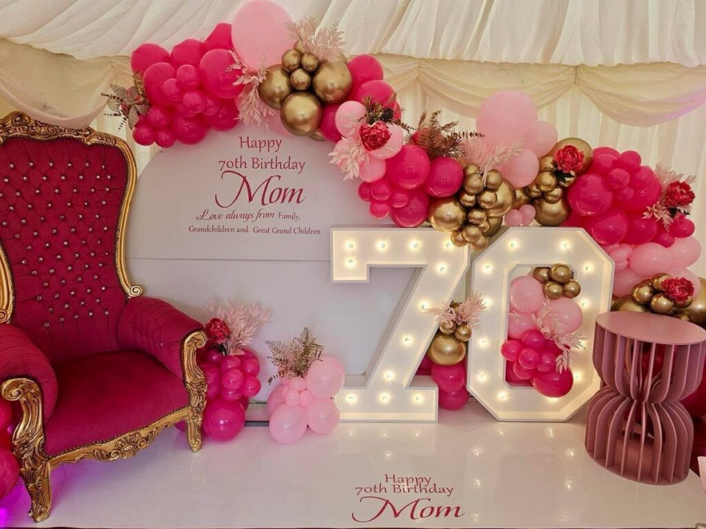 Celebratory 70th birthday setup for mom with magenta chair and glowing numbers