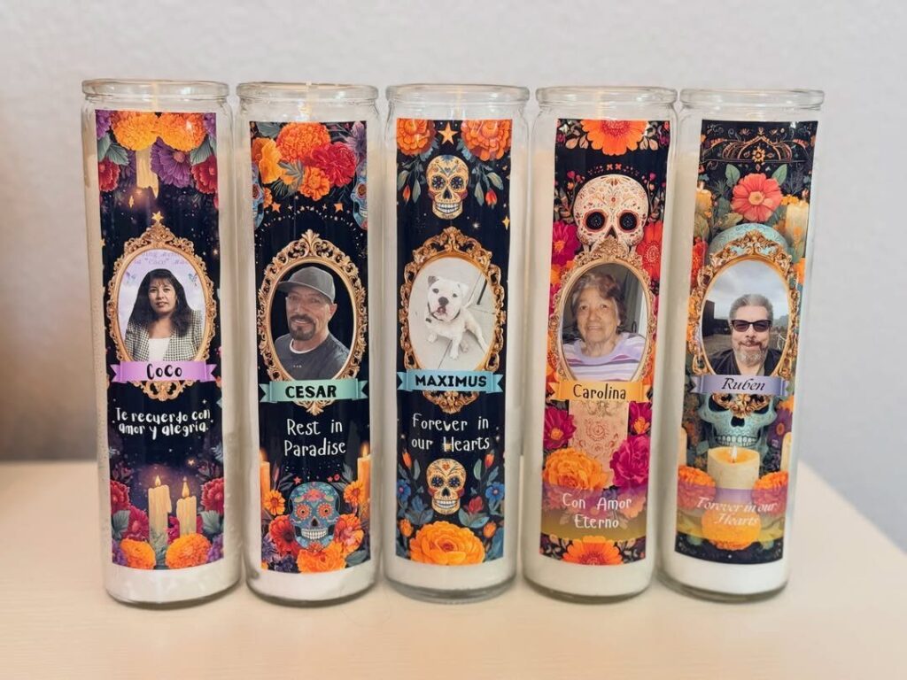 Five personalized memorial pillar candles with portraits and colorful sugar skull decorations.