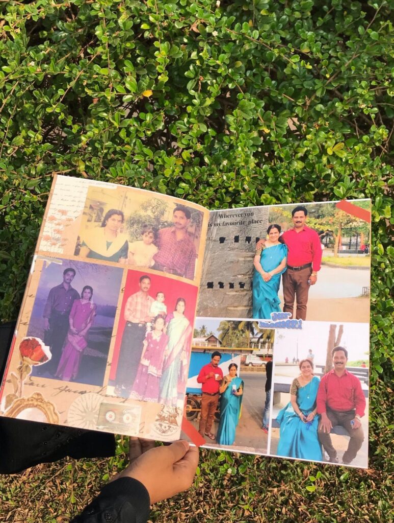 Open photo album with family pictures held over a green leafy hedge background.