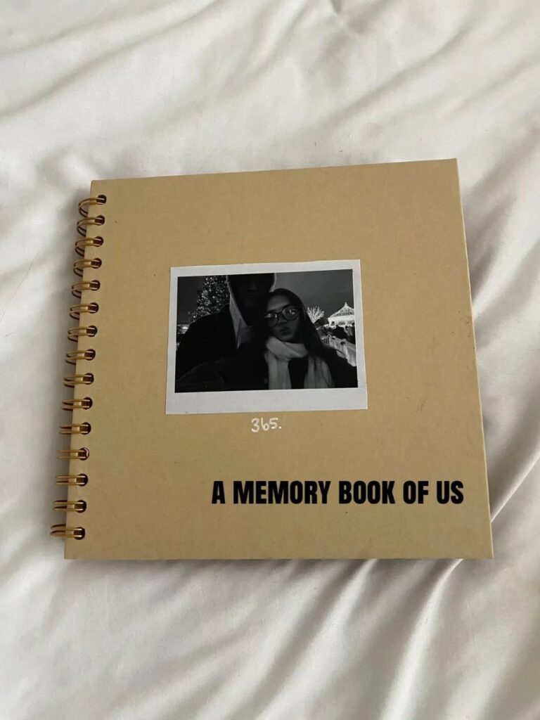 Brown spiral scrapbook with a couple's polaroid and text A Memory Book of Us